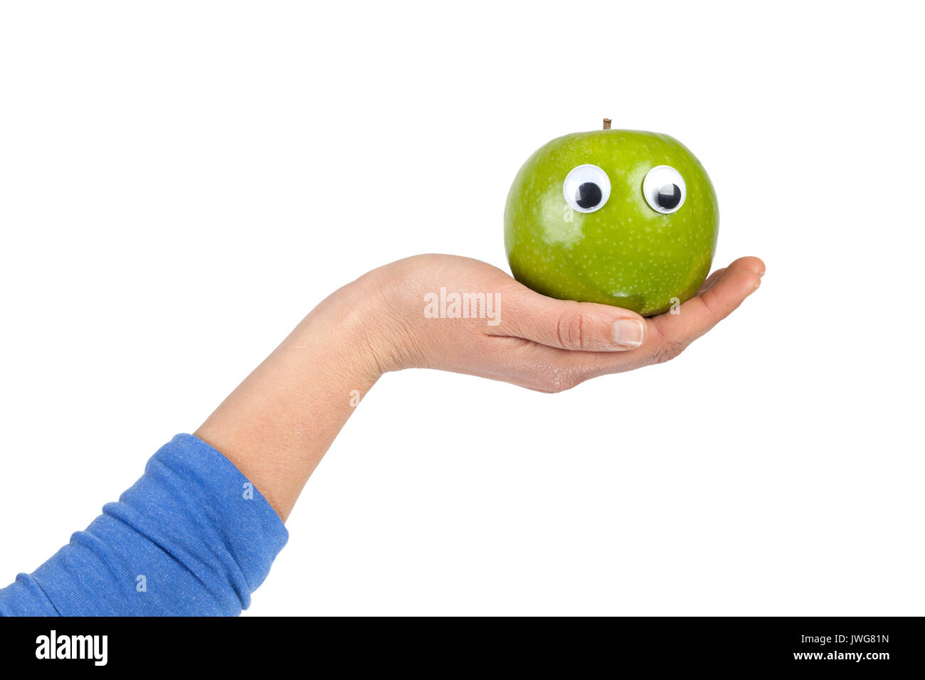 Weibliche Hand green apple mit kulleraugen auf weißem Hintergrund mit Kopie Raum isoliert. Gesundes Essen und Lifestyle Konzept Stockfoto