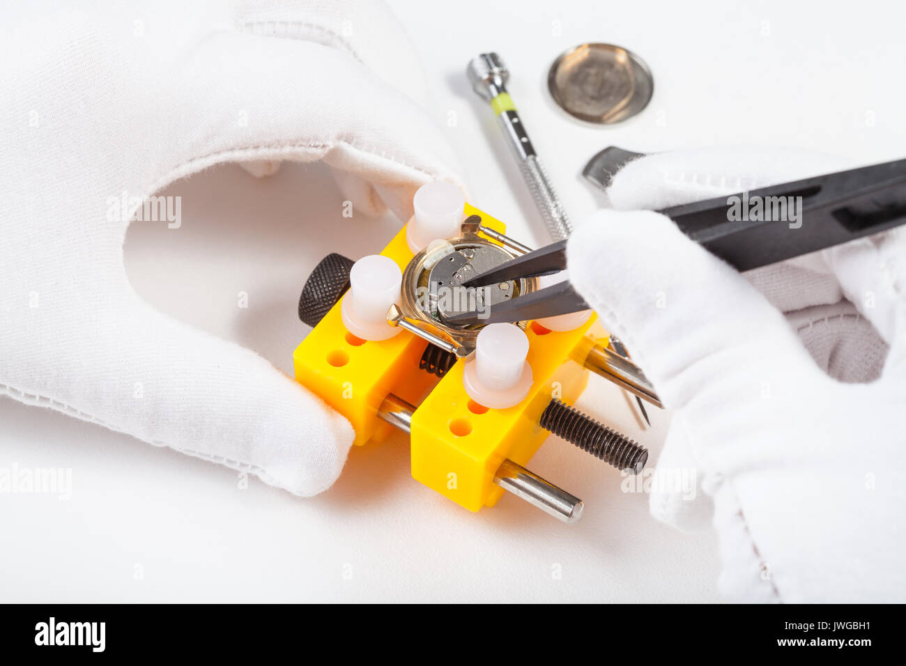 Uhrmacher Workshop - Austauschen einer Batterie im quarzuhr von Pinzette auf weißem Hintergrund Stockfoto
