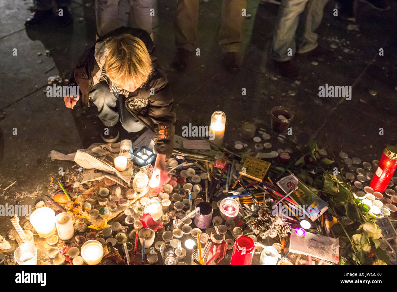 Ein Kind ist die Beleuchtung und eine Kerze. Hommage an die Opfer von Charlie Hebdo Tötung in Paris der 7. Januar 2015. Stockfoto