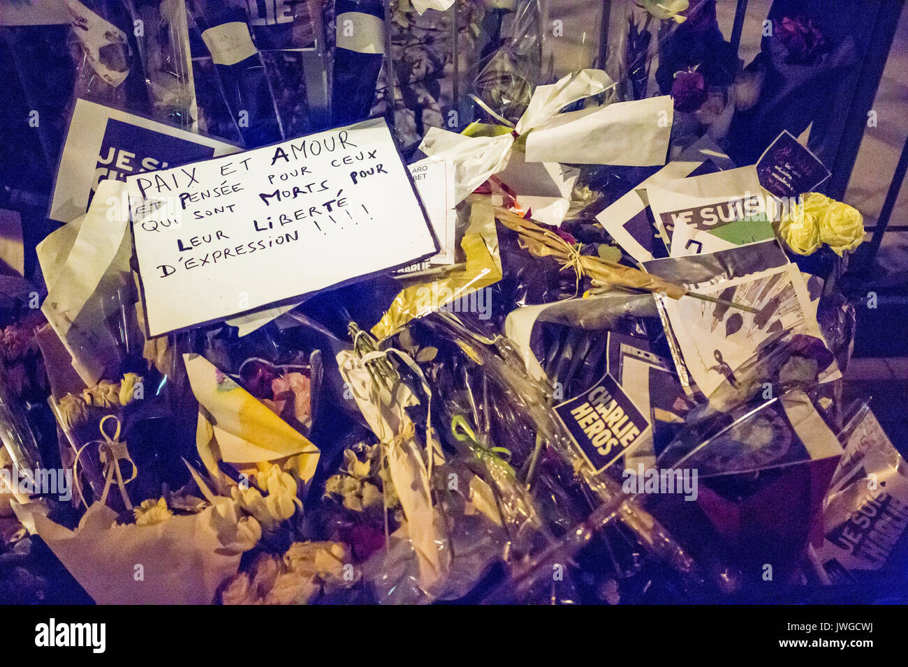 Frieden und Liebe Zeichen stehen heraus unter den Blumen, Paix et amour. Hommage an die Opfer von Charlie Hebdo Tötung in Paris der 7. Januar 2015. Stockfoto