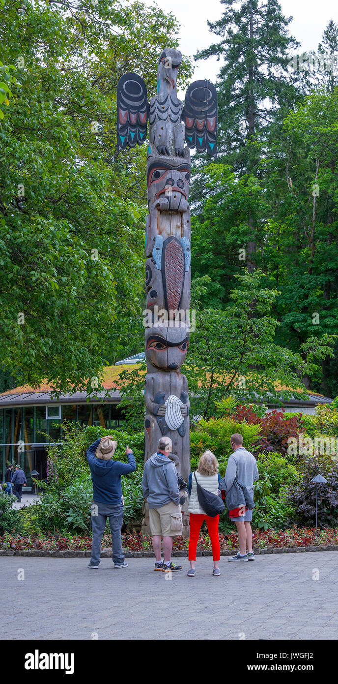 Besucher bewundern einen Totempfahl liegt in den Butchart Gardens Victoria Vancouver Island British Columbia Kanada Stockfoto