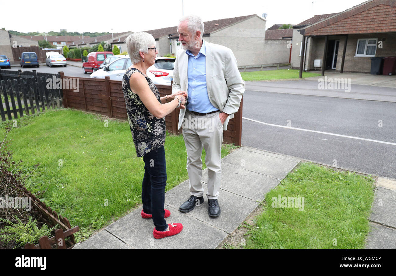 Der Führer der Jeremy Corbyn grüßt Carol Woolford an ihrem Haus im Westen lesen, bevor sie zu ihr sprechen über die Armut. Stockfoto