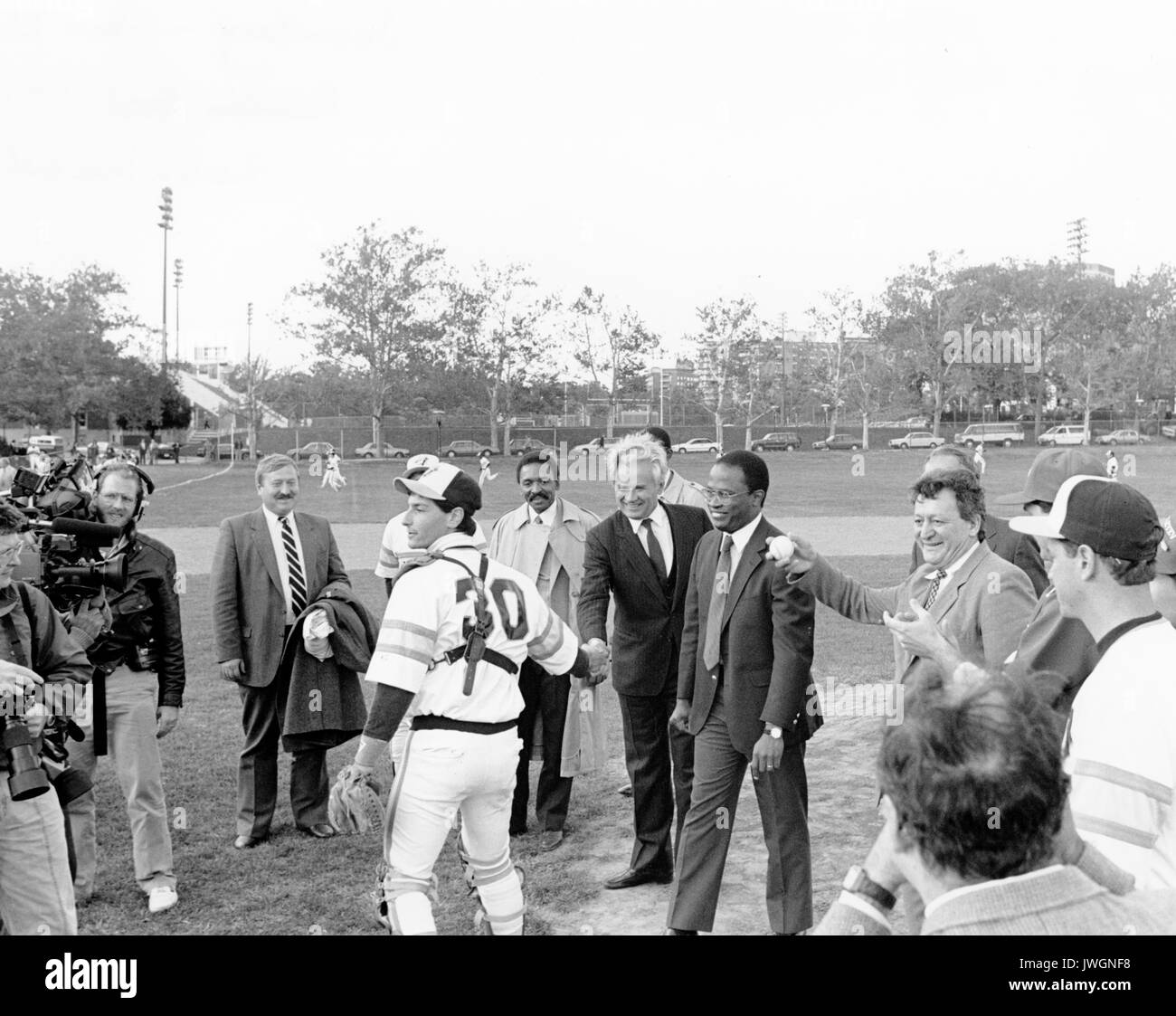 Baseball sowjetischen Botschafter Jurij Dubinin, Kurt Schmoke, der Bürgermeister von Baltimore, D ich Mendelejew Institut für Chemische Technologie vs Hopkins Baseball, Spieler (Catcher) Hände schütteln mit Besuchern, Homewood Feld, 1988. Stockfoto