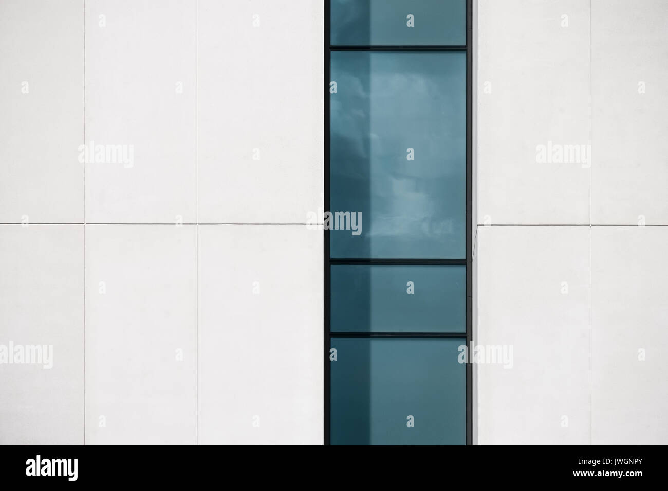 Eine abstrakte close-up, einen Abschnitt einer modernen Gebäude mit einem vertikalen Fenster. Stockfoto