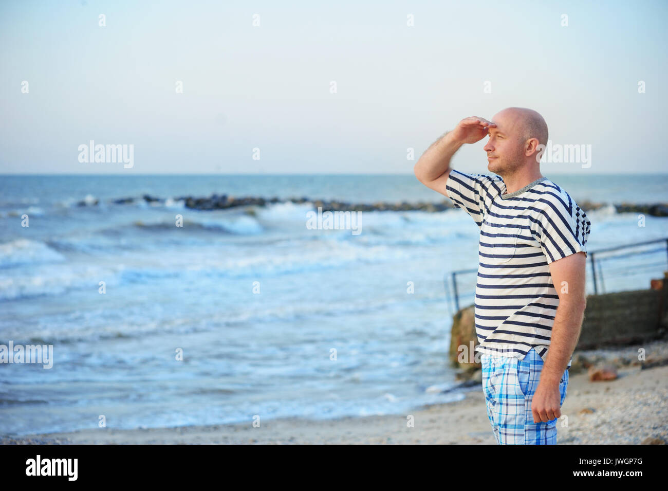 Mann steht am Meer und schaut in die Ferne. Stockfoto Mann steht am Meer und schaut in die Ferne. Stockfoto