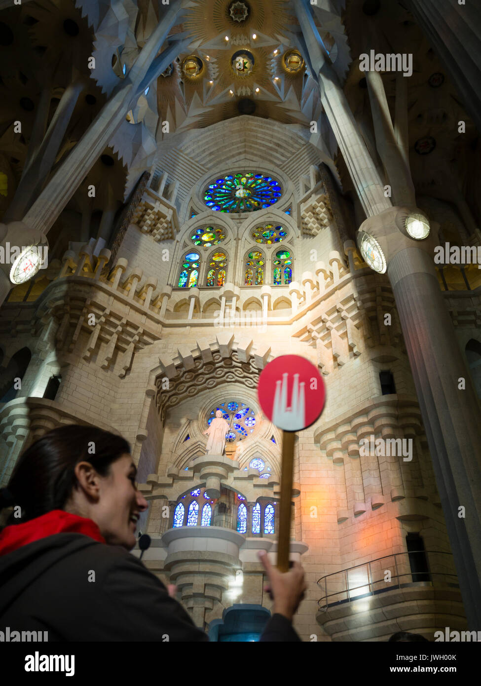 Ein Reiseführer hält ein Schild in Barcelonas Kathedrale Sagrada Familia, die mit Touristen aus aller Welt überfüllt ist. Die noch unfin Stockfoto