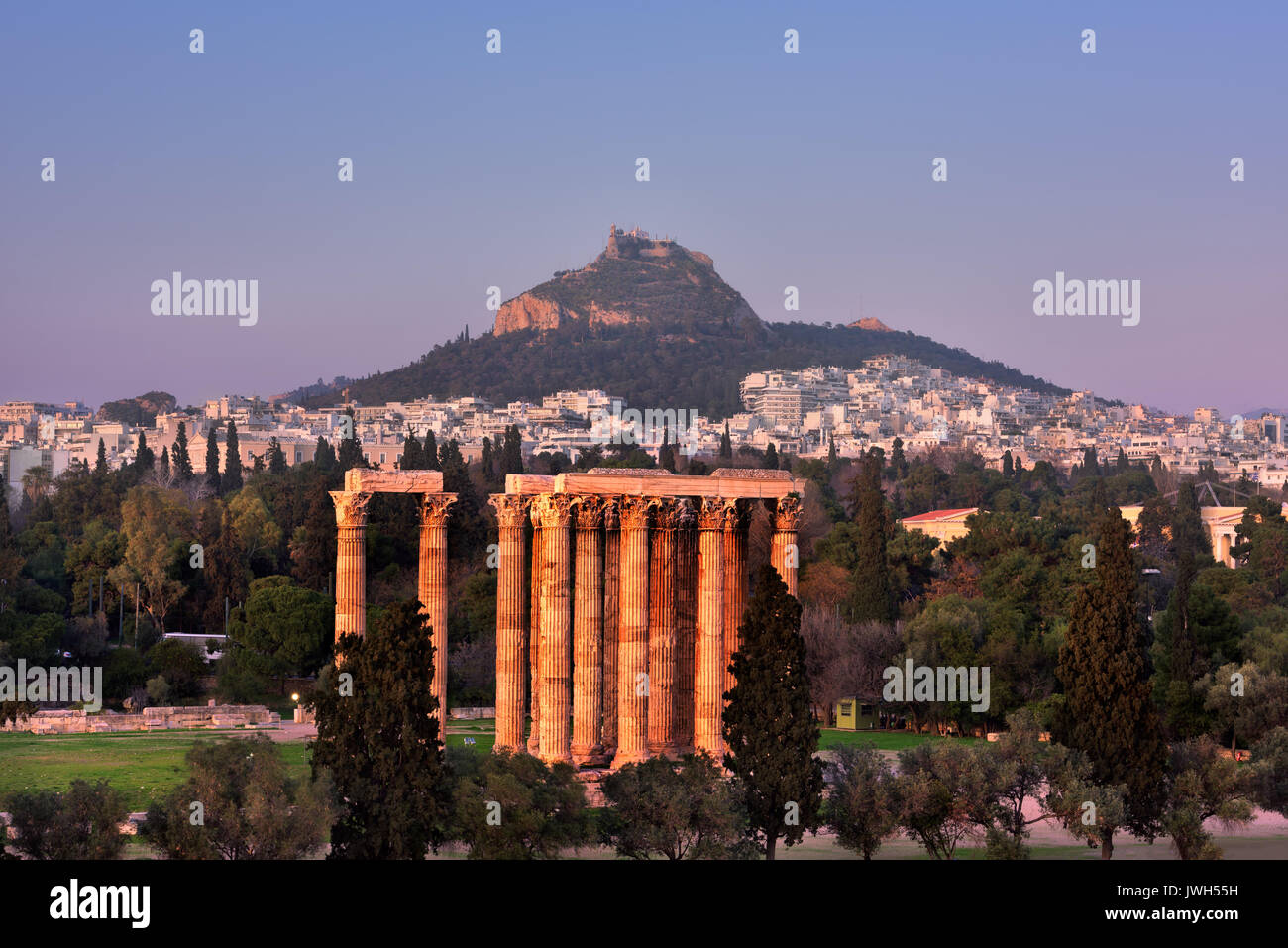 Blick auf den Tempel des Olympischen Zeus und den Berg Lycabettus am Abend, Athen, Griechenland Stockfoto