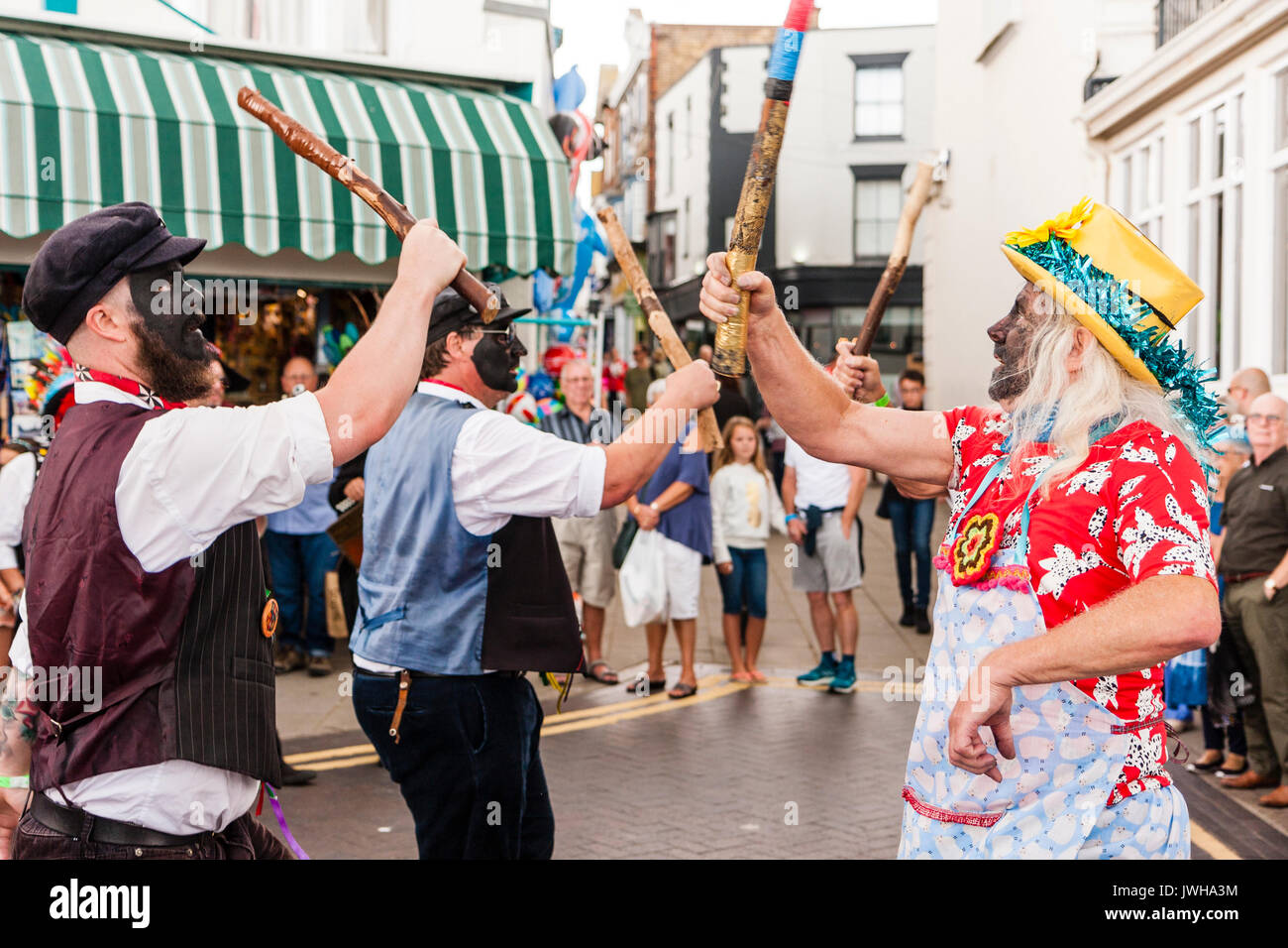 Traditionelle Morris Dancers, Dead Horse Morris tanzen in kleinen Platz in der Stadt während der broadstairs Folk Woche. Männer alle mit geschwärzte Gesichter, plus Morris vormachen, tanzen vor Publikum. Stockfoto