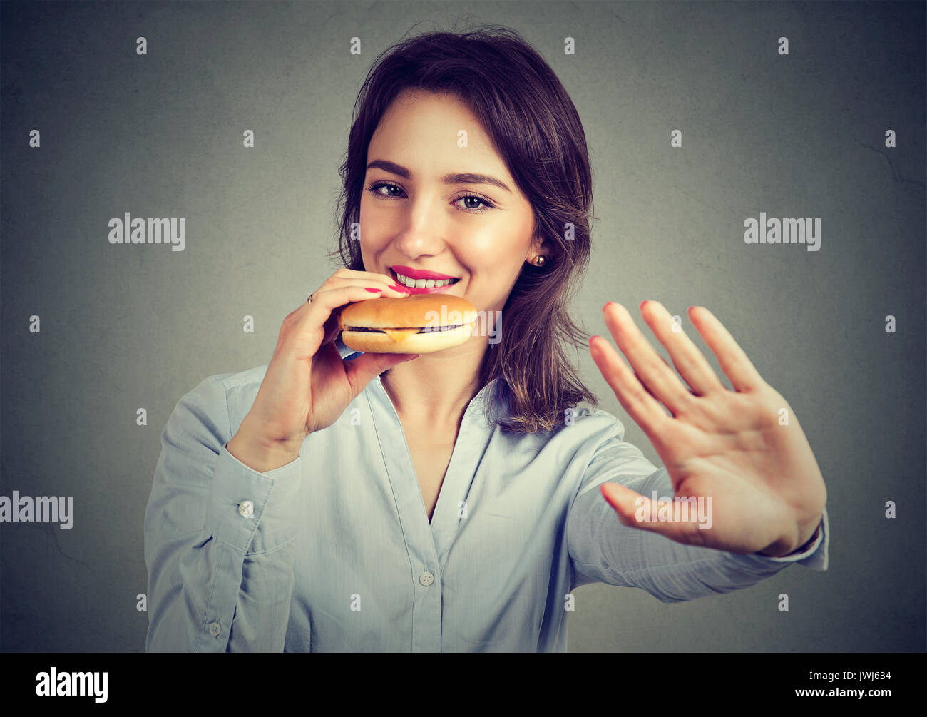 Glückliche Frau sagt Nein zu Ernährung ihre Cheeseburger Stockfoto