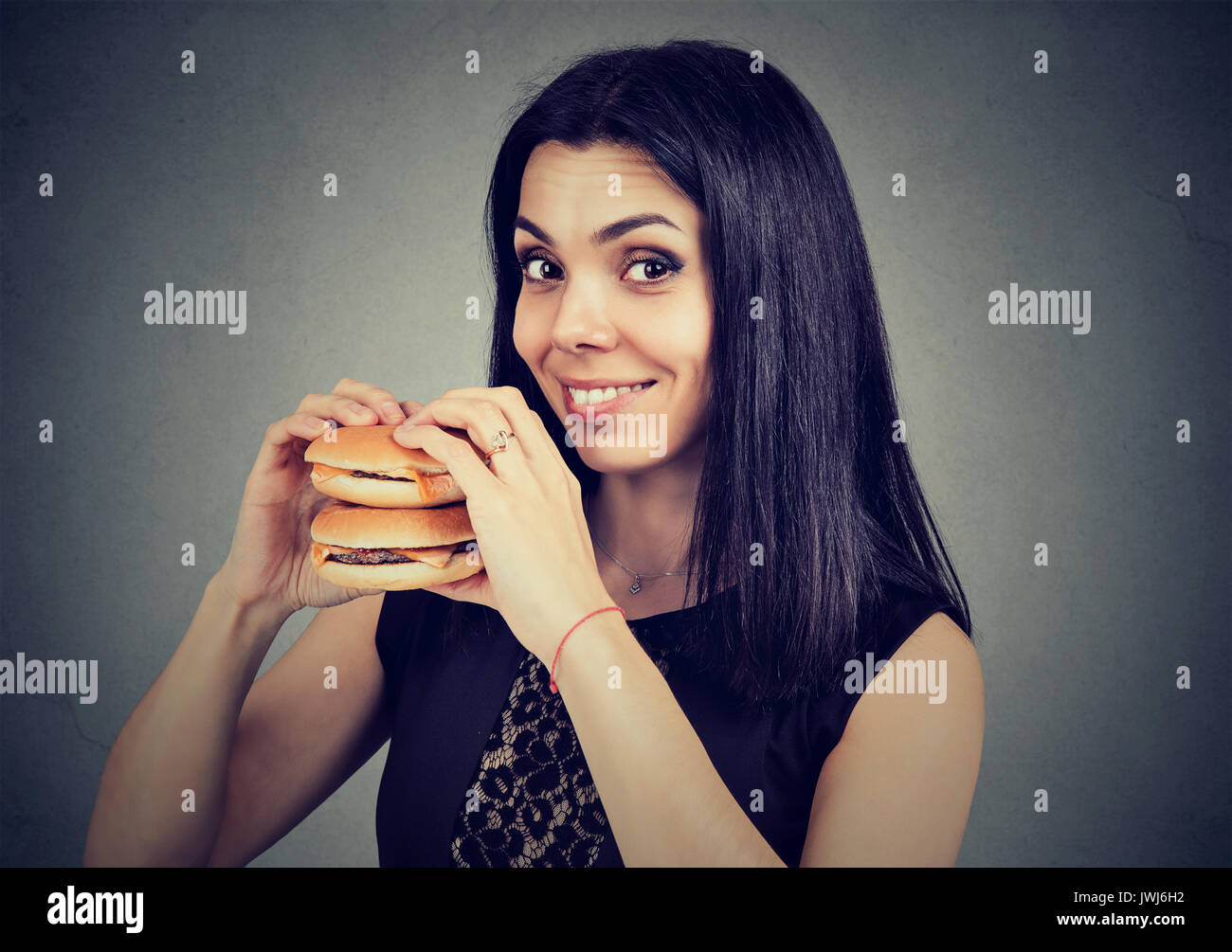Fast Food ist mein Favorit. Frau essen einen Doppelten Cheeseburger genießen Sie den Geschmack Stockfoto