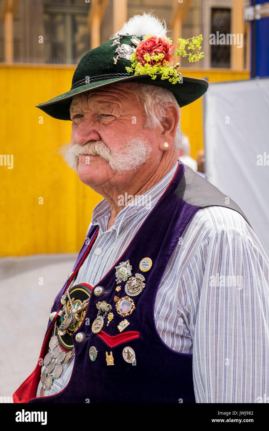 Typisch Bayerische Zeichen in der traditionellen Tracht der Lederhosen, Westen, Hüte mit Federn, Blumen, Emaille Namensschilder, Knochen Schmuck, und Männer disp Stockfoto
