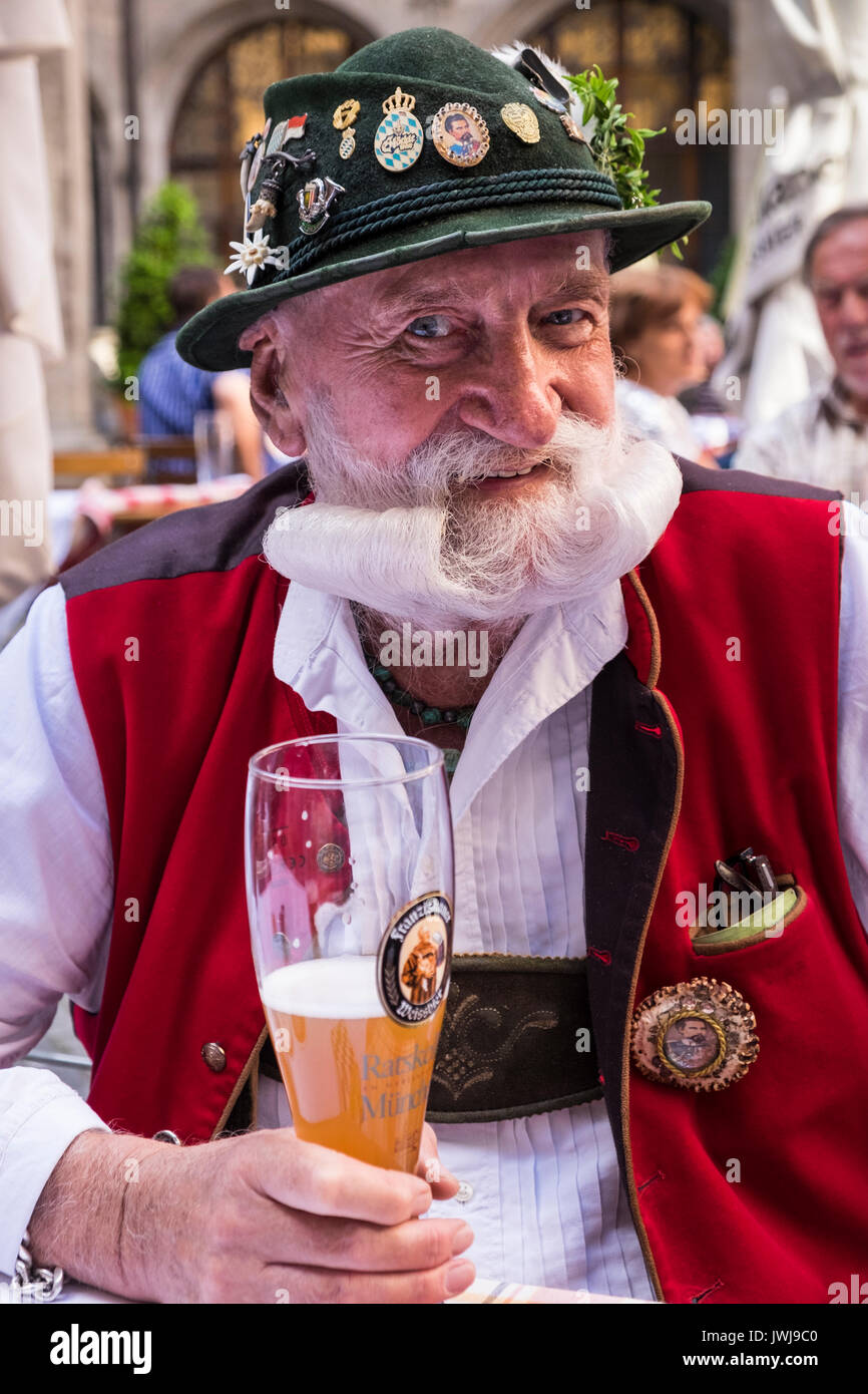 Typisch Bayerische Charakter in der traditionellen Tracht der Lederhosen, Weste, Hut mit Emaille Schilder, Schmuck und Anzeigen der extravagante Bärte und Stockfoto