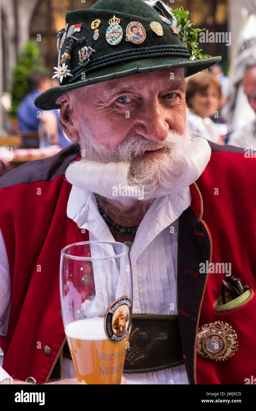Typisch Bayerische Charakter in der traditionellen Tracht der Lederhosen, Weste, Hut mit Emaille Schilder, Schmuck und Anzeigen der extravagante Bärte und Stockfoto
