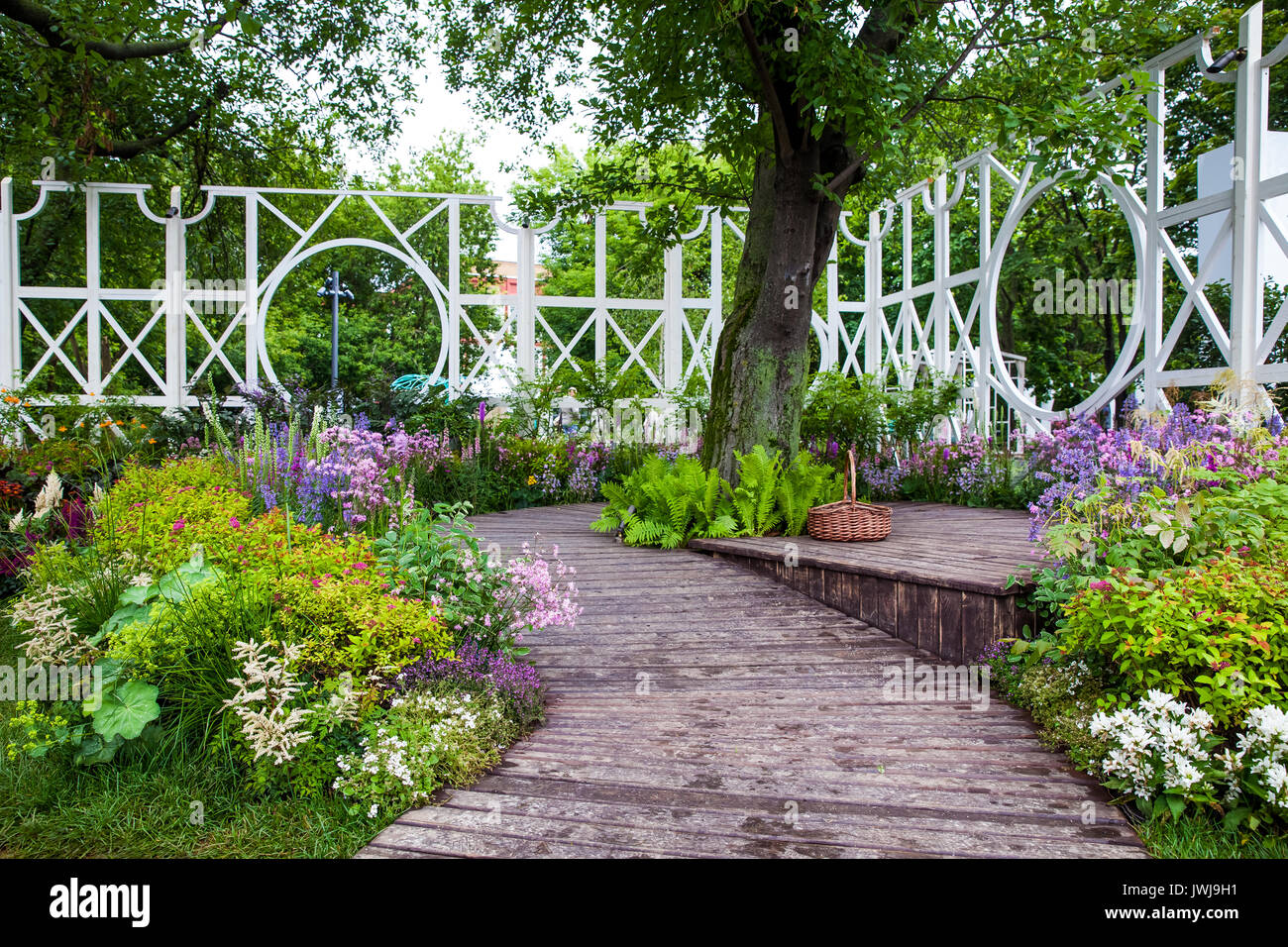 Landschaftsdesign Garten mit dekorativen Blumen und Holz- pfad Straße Stockfoto