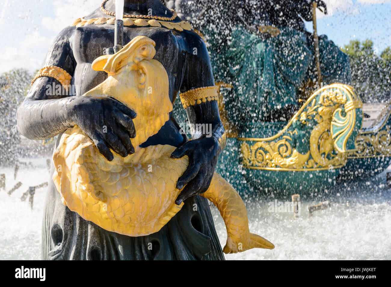 Nahaufnahme des Seebrunnen auf dem Concorde-Platz in Paris mit einer Statue eines Nereid, der einen goldenen Fisch hält, der Wasser nach oben spuckt. Stockfoto