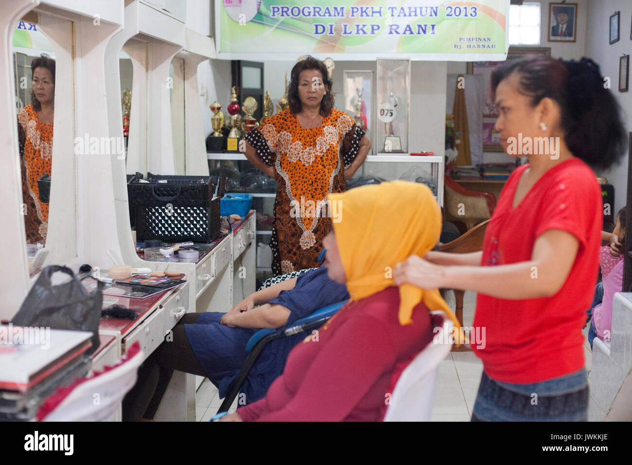 Ibu Haja Hasna ist ein weiteres erfolgreiches transgender Frau besitzen eine Hochzeit Organisation von Unternehmen im Süden von Sulawesi. Sie hat ihre Beauty Salon und Hochzeit organisieren Unternehmen 1976 begann, eines der ältesten und berühmtesten im Bereich der Sidrap, wo sie lebt. Sie hat zahlreiche regionale und nationale Auszeichnungen in Bugis traditionelle Hochzeit Make-up-Wettbewerbe, die in ihrer Limousine angezeigt werden gewonnen. Heute, Ibu Haja Hasna bevorzugt die Arbeit ihrer Mitarbeiter im Beauty Salon zu überwachen. Sie wählt ihre Mitarbeiter aus dem Studenten die Teilnahme an der kostenfreien traditionellen Buginese Make-up-Klassen organisiert Sie Stockfoto