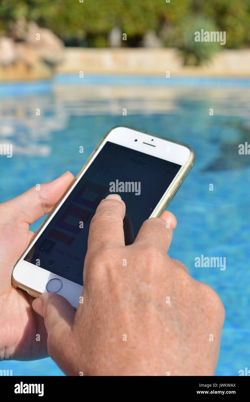 Frau verwenden drahtlose Technologie im Pool. Stockfoto