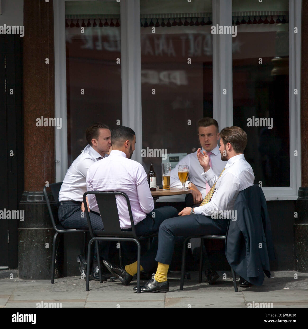 LONDON, ENGLAND - 11. August 2017 vier Männer in weißen Hemden haben ein Mittagessen in einem Straßencafe in der Nähe von Piccadilly Circus Stockfoto