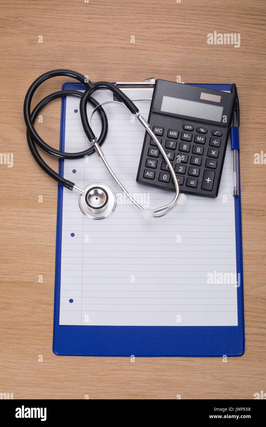 Metall schwarz und silber stethescope und Kunststoff schwarz Taschenrechner auf leeren Notizblock mit Stift oben auf Blau Zwischenablage Stockfoto