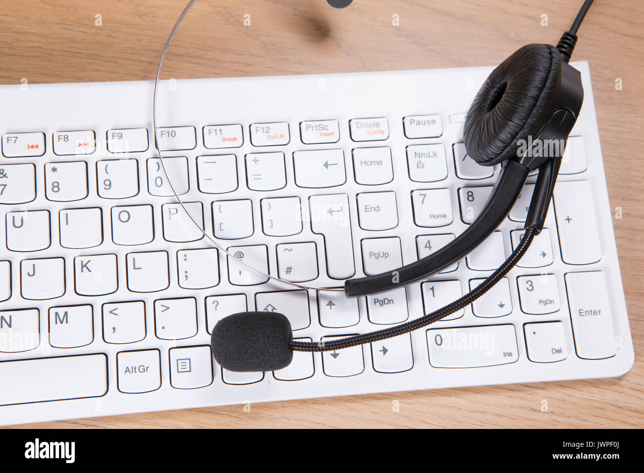 Weiß computer Tastatur mit Headset in einem Online- oder Business Communication Konzept für Telemarketing, Live Chat oder ein Call Center Stockfoto