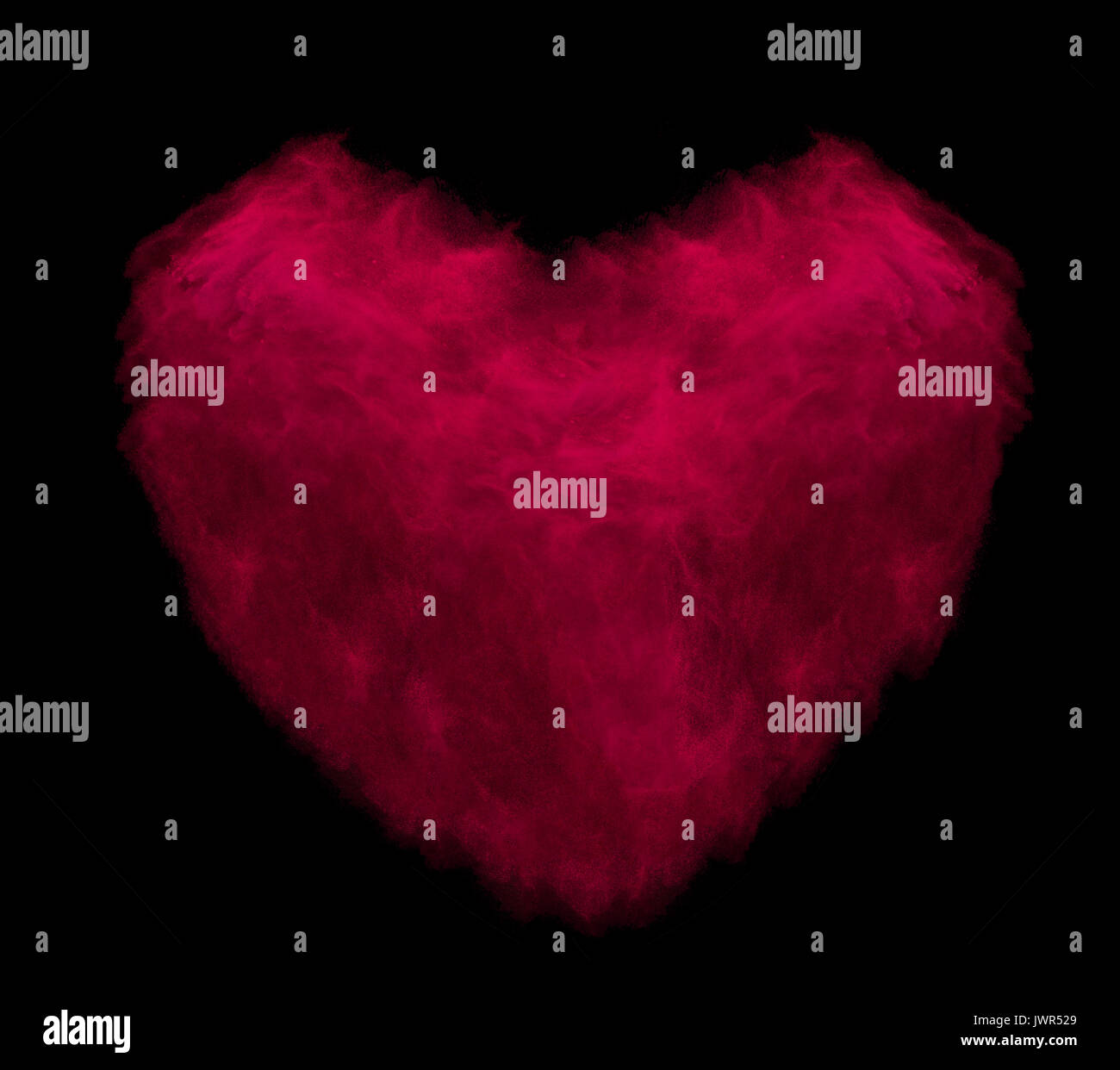 Rotes Herz aus Pulver Explosion auf schwarzem Hintergrund Stockfoto