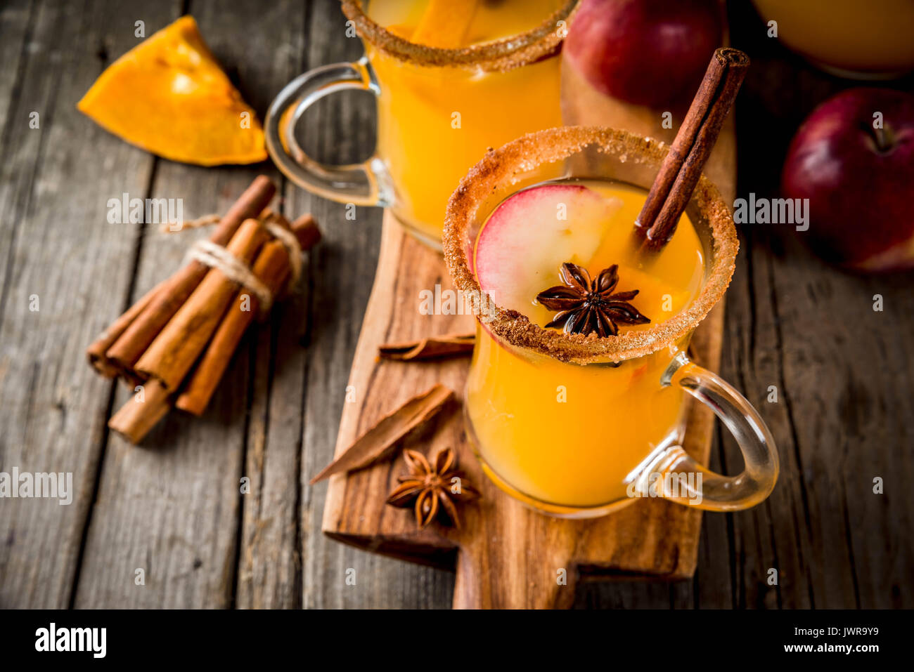 Halloween, Thanksgiving. Traditionelle Herbst, Winter Getränke und Cocktails. Pikanten Kürbis Sangria, mit Apfel, Zimt, Anis. Auf alten Holzmöbeln im Landhausstil Stockfoto