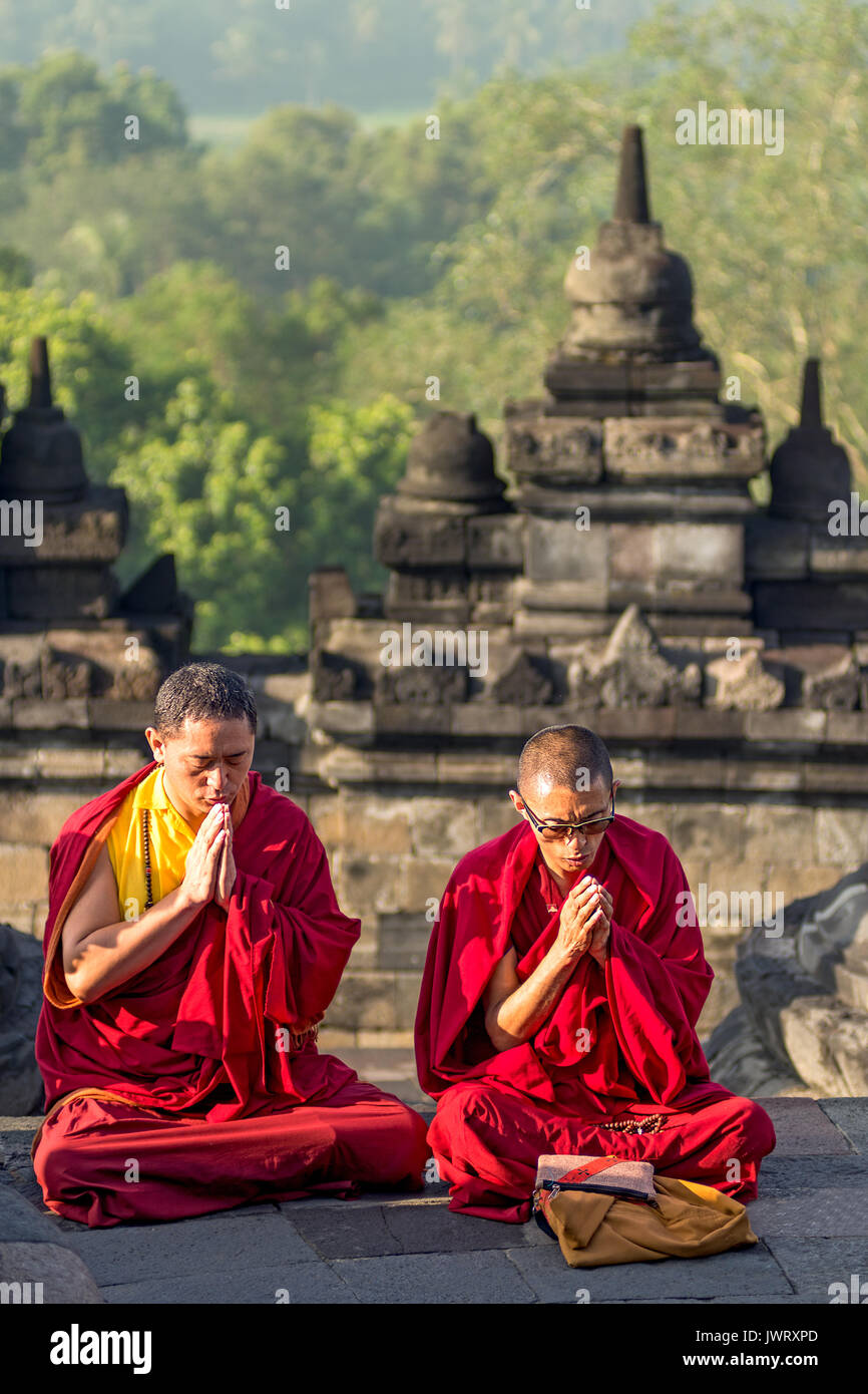 Rot gekleideten Mönche beten bei Sonnenaufgang am Weltkulturerbe Borobudur buddhistischen Tempel. Stockfoto