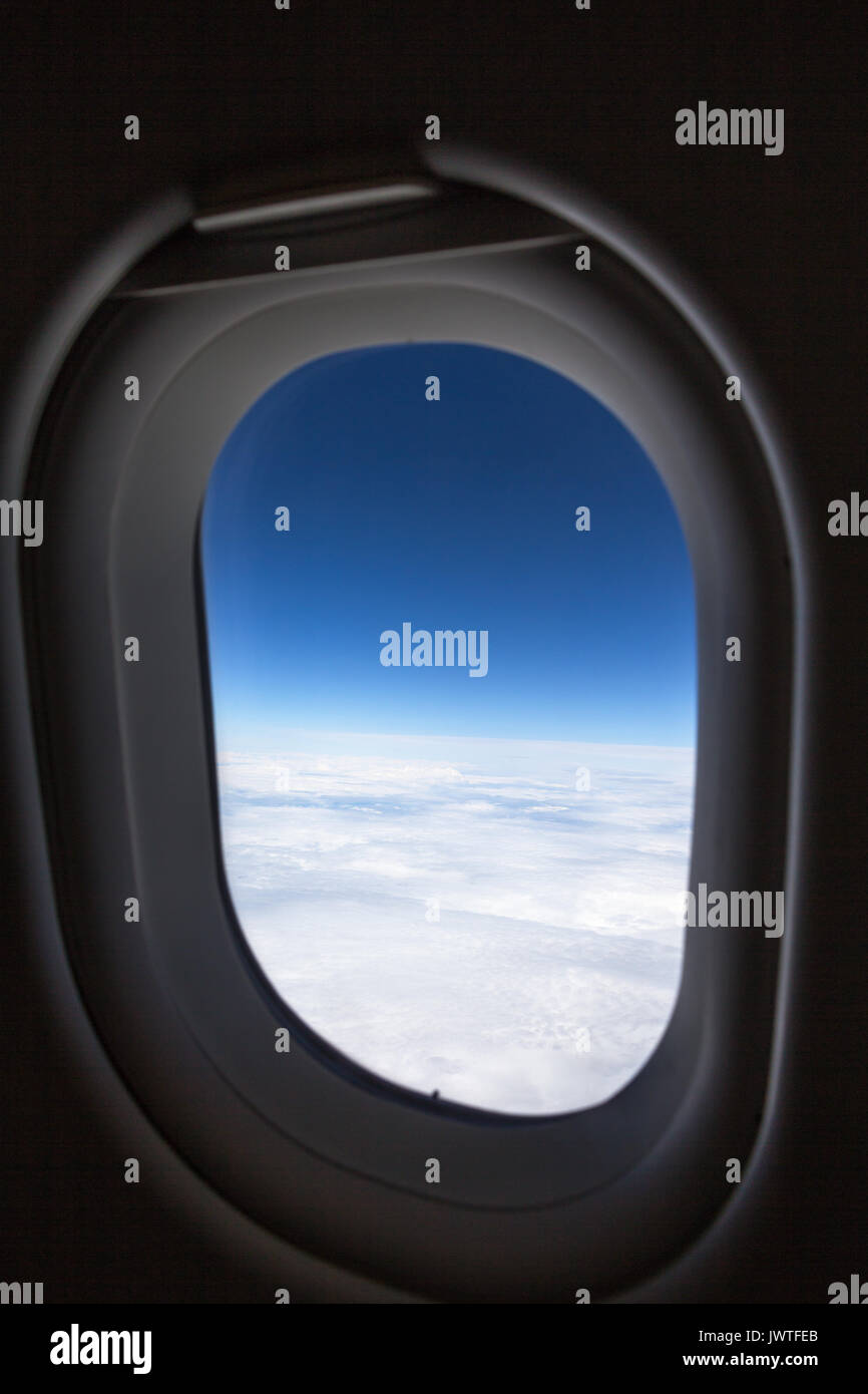 Vertikaler Flugzeug Fenster, weiße Wolken füllen die untere Hälfte des Fenster mit blauen Himmel Vertiefung in Farbe Nach oben Stockfoto