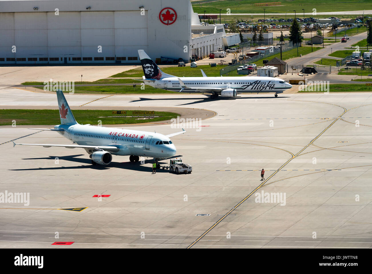 Air Canada Airline Airbus A 320-214 Airliner C-GJVT geschleppt wird zu stehen und Alaska Airlines Boeing 737-890 (w) in Calgary Alberta Kanada Rollens Stockfoto