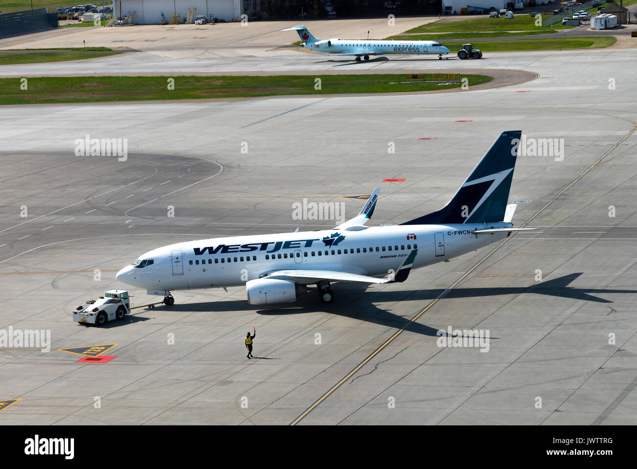 Westjet Airlines Boeing 737-7 CT (w) Airliner C-FWCN wird von einem Schlepper abgeschleppt auf internationalen Flughafen Calgary Alberta Kanada Stand Stockfoto