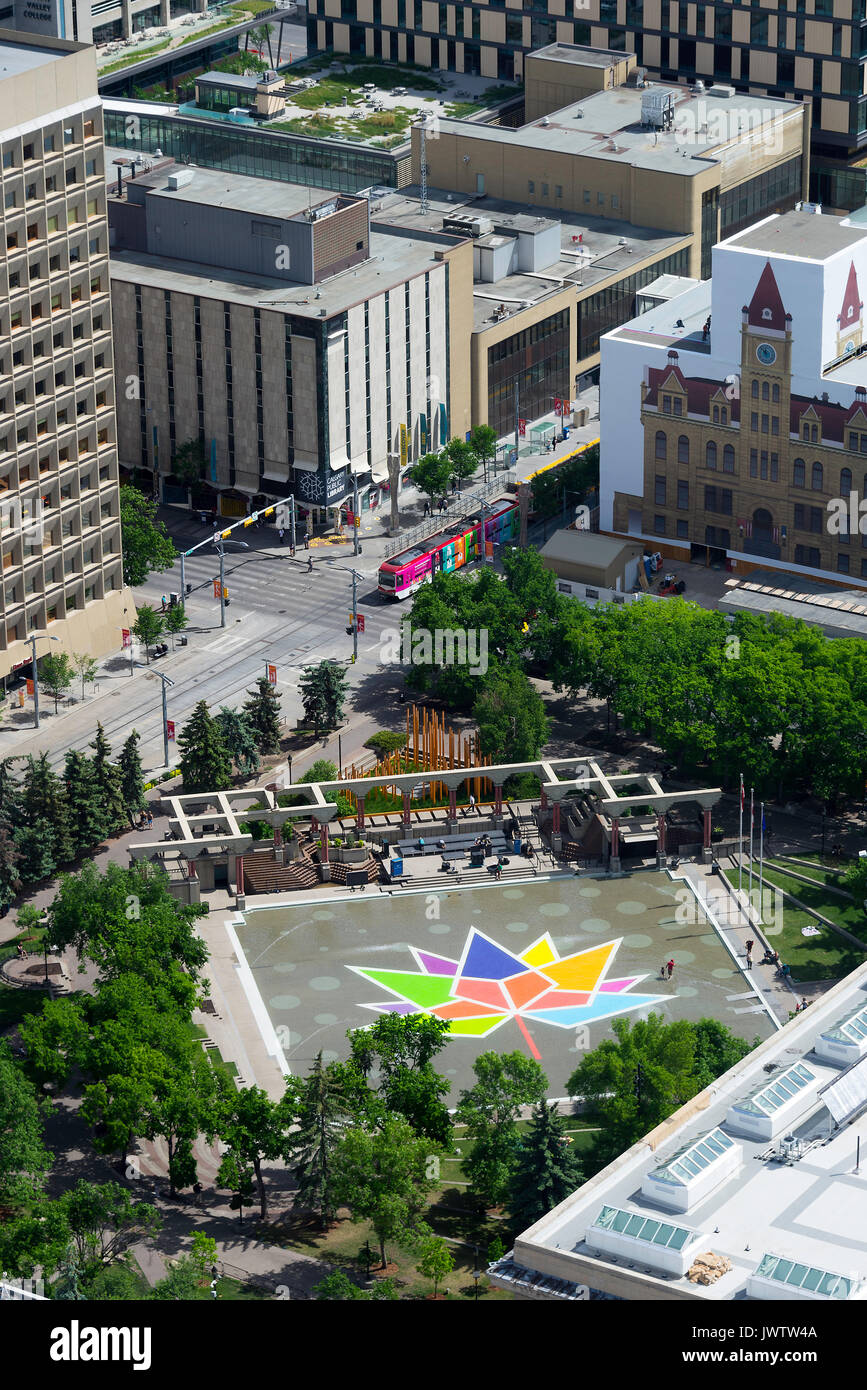 Eine bunte Maple Leaf in der Olympic Plaza mit einem Calgary Transit Personenzug in Calgary, Alberta, Kanada von der Calgary Tower Embedded Stockfoto