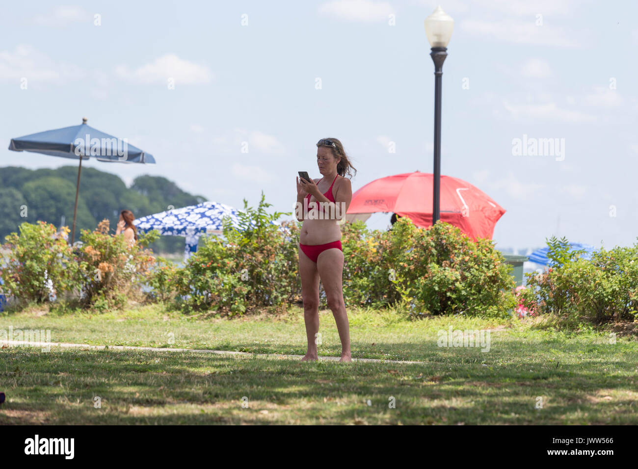 Norwalk, Connecticut, USA, Sonntag, 13. August 2017 Es war ein warmer 80 (f) Grad Tag mit geringer Luftfeuchtigkeit für die lokale Kalb auf der Weide Strandurlauber. Vielmehr drücken die Zwillinge im Kinderwagen der Versand einer SMS jeder nimmt einen Moment an diesem Sommertag. Credit: Craig Perry/Popupphoto/Alamy leben Nachrichten Stockfoto