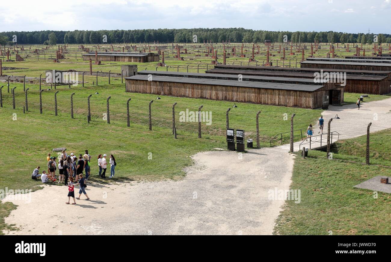 Die Besucher gehen über die ehemaligen Konzentrationslager Auschwitz-Birkenau in Oswiecim, Polen, 26. Juni 2017. Die wichtigsten paramilitärischen Organisation im nationalsozialistischen Deutschland, SS (Schutzstaffel, lit. "Schutz Squadron"), lief die Konzentrations- und Vernichtungslager zwischen 1940 und 1945. Eingehende Deportierten wurden in verschiedene Gruppen, die auf der Rampe zwischen den Tracks ausgewählt, nachdem Sie in Birkenau angekommen. Die Menschen, die nicht in der Lage waren zu arbeiten (ältere Menschen, Menschen mit schwachen, Frauen, Kinder) waren manchmal zu den Gaskammern direkt ohne Registrierung gesendet. Etwa 1,1 bis 1,5 Millionen Menschen, die meisten von ihnen Jüdisch, haben werden. Stockfoto