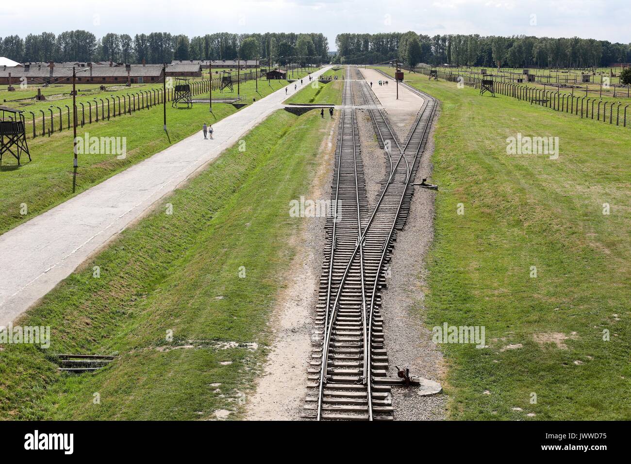 Die Besucher gehen über die ehemaligen Konzentrationslager Auschwitz-Birkenau in Oswiecim, Polen, 26. Juni 2017. Die wichtigsten paramilitärischen Organisation im nationalsozialistischen Deutschland, SS (Schutzstaffel, lit. "Schutz Squadron"), lief die Konzentrations- und Vernichtungslager zwischen 1940 und 1945. Eingehende Deportierten wurden in verschiedene Gruppen, die auf der Rampe zwischen den Tracks ausgewählt, nachdem Sie in Birkenau angekommen. Die Menschen, die nicht in der Lage waren zu arbeiten (ältere Menschen, Menschen mit schwachen, Frauen, Kinder) waren manchmal zu den Gaskammern direkt ohne Registrierung gesendet. Etwa 1,1 bis 1,5 Millionen Menschen, die meisten von ihnen Jüdisch, haben werden. Stockfoto