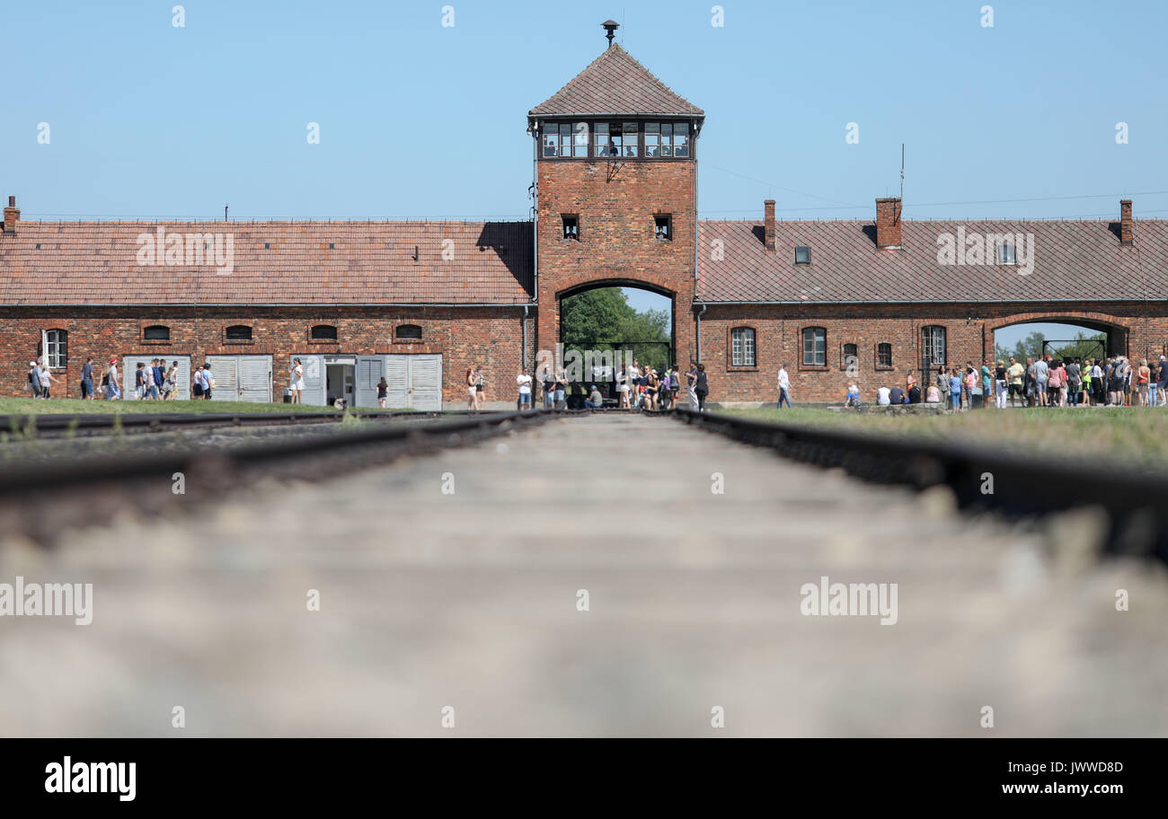 Die Besucher gehen vor dem historischen Tor, durch das ehemalige Konzentrationslager Auschwitz-Birkenau in Oswiecim, Polen, 21. Juni 2017. Die wichtigsten paramilitärischen Organisation im nationalsozialistischen Deutschland, SS (Schutzstaffel, lit. "Schutz Squadron"), lief die Konzentrations- und Vernichtungslager zwischen 1940 und 1945. Eingehende Deportierten wurden in verschiedene Gruppen, die auf der Rampe zwischen den Tracks ausgewählt, nachdem Sie in Birkenau angekommen. Die Menschen, die nicht in der Lage waren zu arbeiten (ältere Menschen, Menschen mit schwachen, Frauen, Kinder) waren manchmal zu den Gaskammern direkt ohne Registrierung gesendet. Etwa 1,1 bis 1,5 Millionen peo Stockfoto