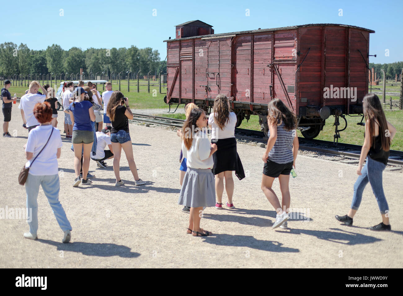 Die Besucher werden auf einem Güterwagen in der Nähe der berüchtigten Rampe im ehemaligen Konzentrationslager Auschwitz in Oswiecim, Polen, 26. Juni 2017. Die wichtigsten paramilitärischen Organisation im nationalsozialistischen Deutschland, SS (Schutzstaffel, lit. "Schutz Squadron"), lief die Konzentrations- und Vernichtungslager zwischen 1940 und 1945. Eingehende Deportierten wurden in verschiedene Gruppen ausgewählt, nachdem Sie in Birkenau angekommen. Die schwachen und kranken Menschen waren manchmal direkt in die Gaskammern, ohne sie selbst Registrierung senden. Etwa 1,1 bis 1,5 Millionen Menschen, die meisten von ihnen Jüdisch, haben im Camp und Seine sa getötet worden Stockfoto