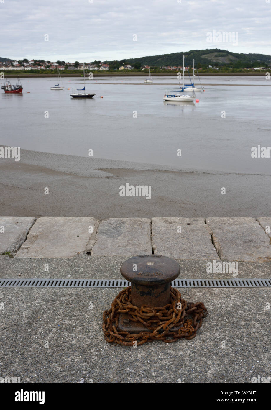 Kai festmachen Poller mit rostigen Kette in Conwy Hafen, North Wales Stockfoto