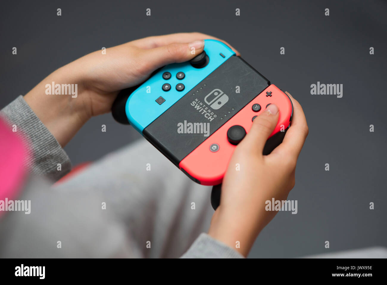 Ein Kind hält einen Control Pad während der Wiedergabe auf einem Nintendo Spiel wechseln. Stockfoto