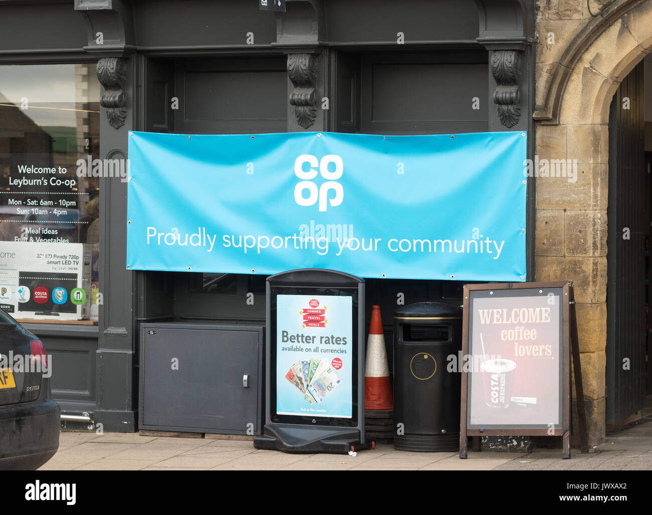 Co-op-Zeichen, stolz ihre Gemeinschaft, Leyburn, Wensleydale, North Yorkshire, England, UK unterstützt Stockfoto