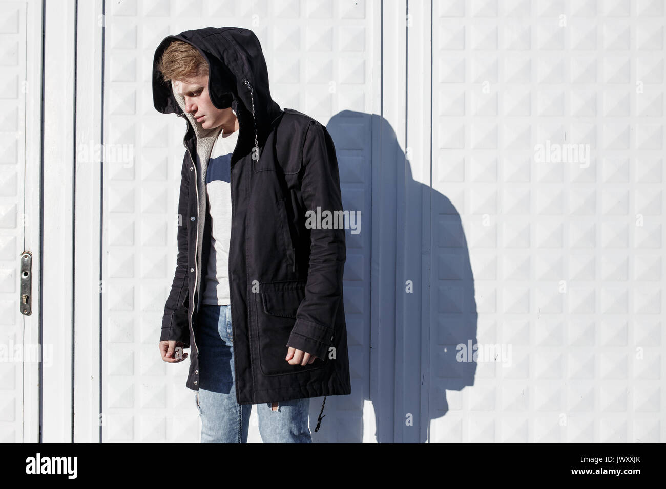 Junge stilvolle rothaarige Mann im trendigen Outfit gegen städtischen Hintergrund posiert Stockfoto