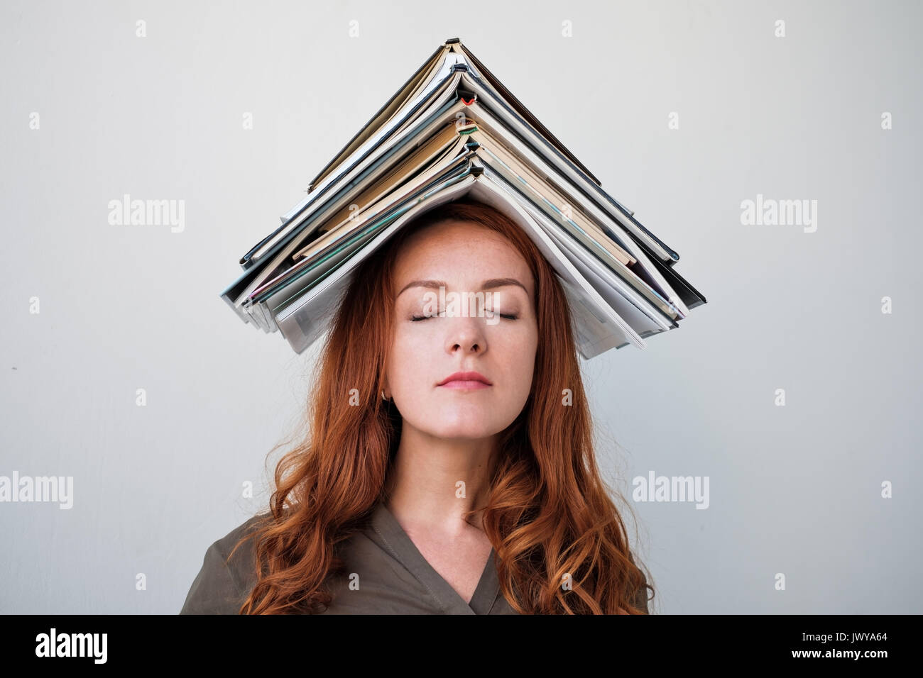 Attraktive junge Frau Balancing ein Buch auf dem Kopf, weißer Hintergrund Stockfoto
