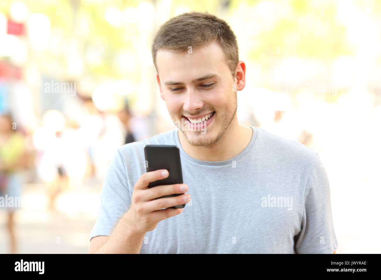 Glückliche Kerl mit einem Smart Phone und gehen auf die Straße Stockfoto