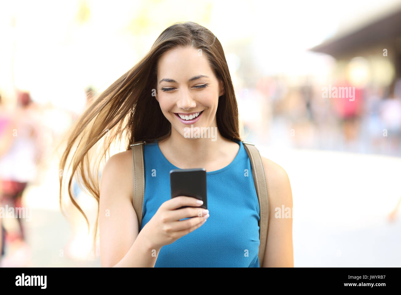 Vorderansicht Porträt einer Frau SMS auf dem Handy gehen auf die Straße Stockfoto