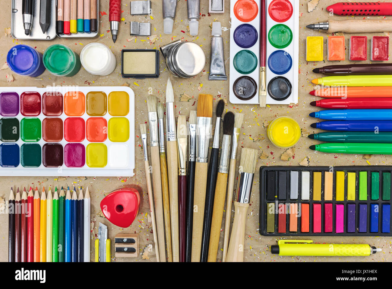 Artist Schreibtisch mit Wasserfarben, Bunte Bleistifte, pastellkreideblöckchen und verschiedene Pinsel Stockfoto