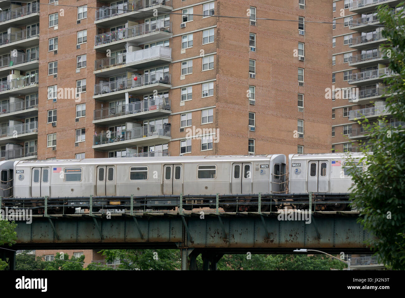 Eine laute erhöhten New York City U-Bahn Zug mehrere Mietshäuser in Brighton Beach in Brooklyn, New York Stockfoto