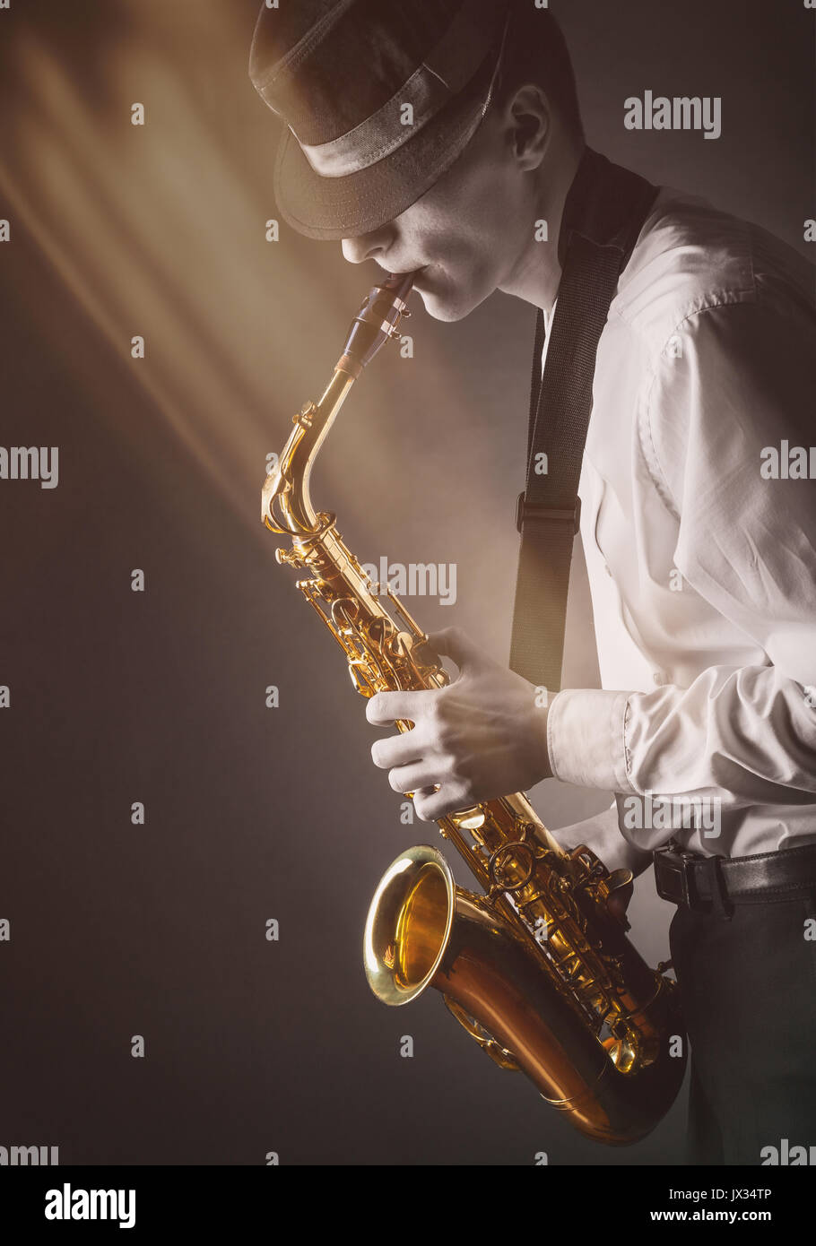 Junge Musiker Saxophon in den Strahlen des Lichts Stockfoto