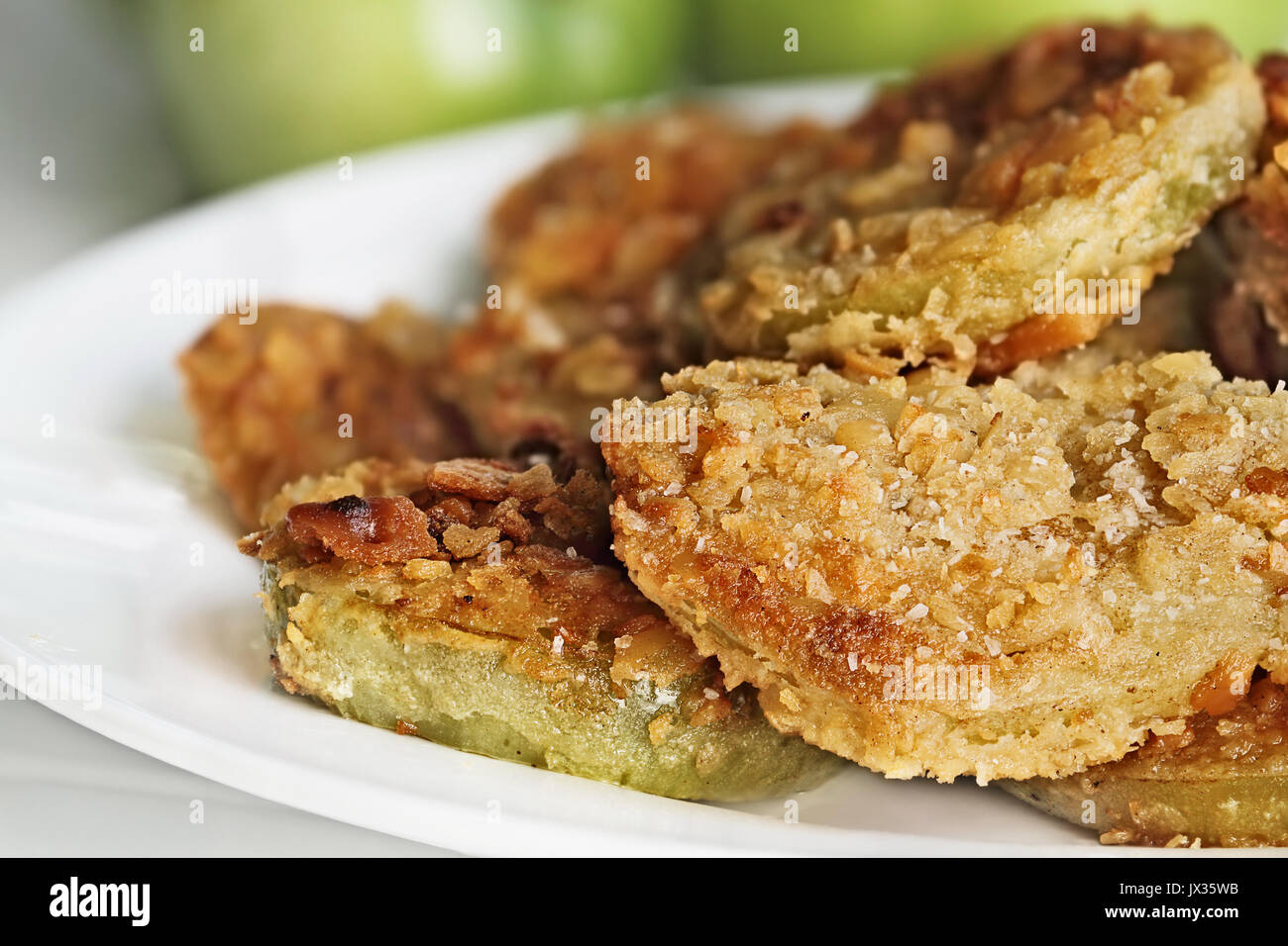 Teller mit frischen gebratenen grünen Tomaten. Tomaten haben im Cracker Krümel beschichtet worden vor dem Braten. Extrem flache Tiefenschärfe mit selektiven Fokus. Stockfoto