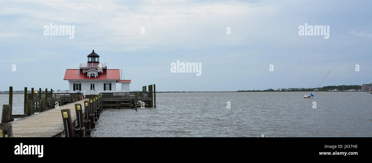 Eine teilweise eingetaucht Segelboot ruht die Roanoke Marschen Leuchtturm in Shallowbag Bay vor der Stadt von Tuba City auf den Outer Banks von North Carolina Stockfoto