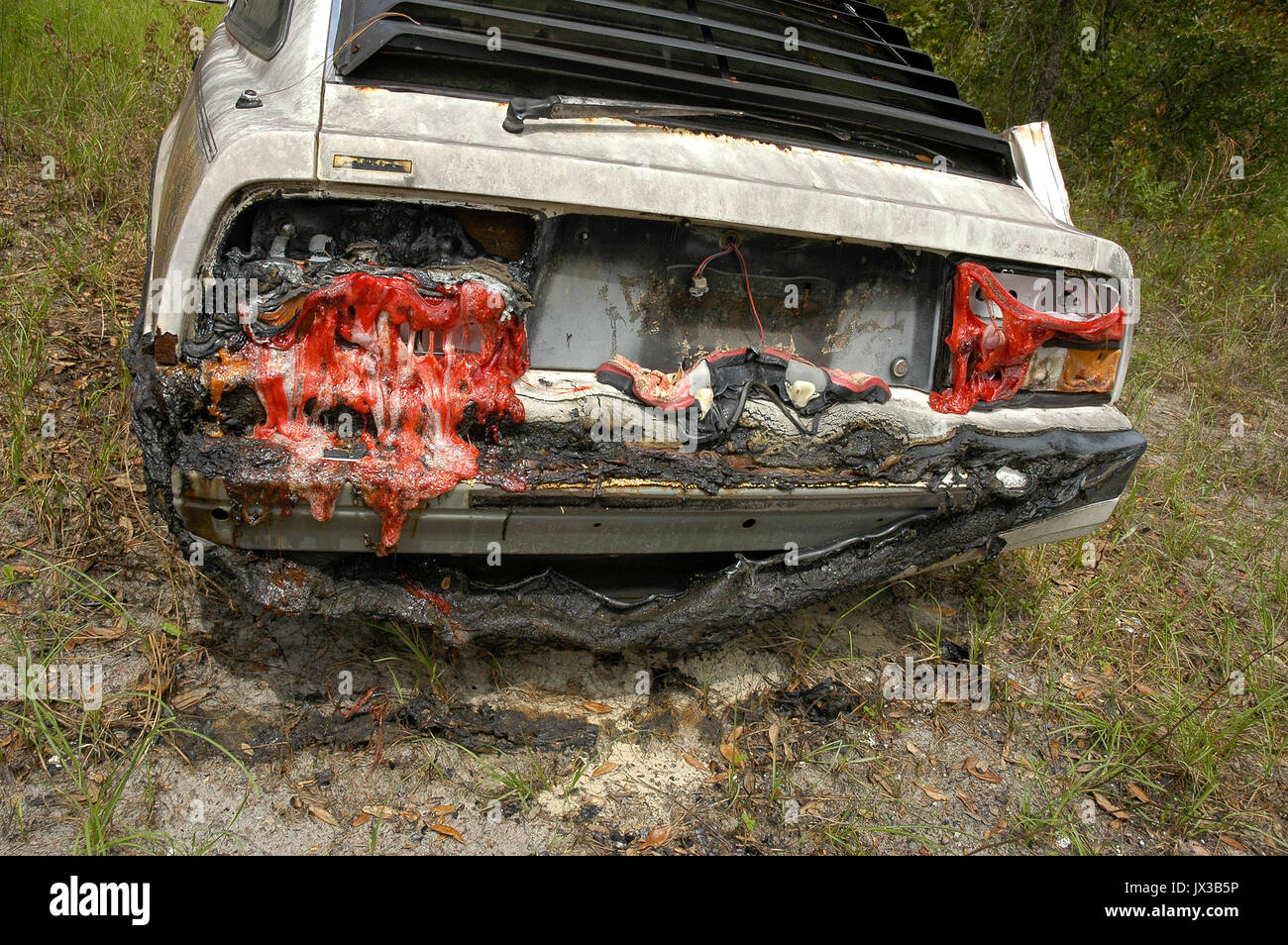 Auto verbrannt in einem Haus Feuer mit geschmolzener Kunststoff Rückleuchten. Stockfoto