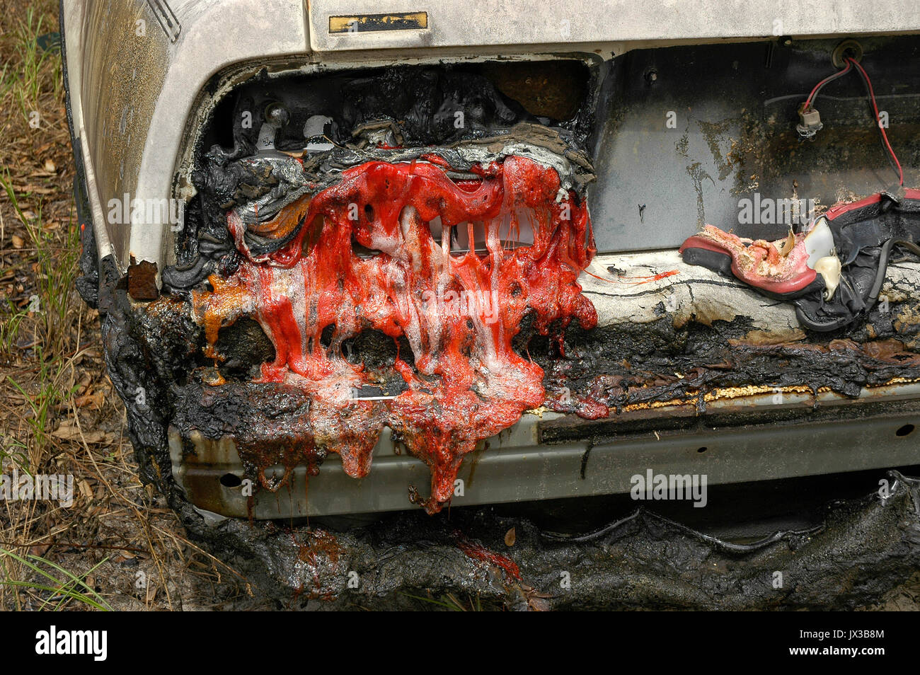 Auto verbrannt in einem Haus Feuer mit geschmolzener Kunststoff Rückleuchten. Stockfoto